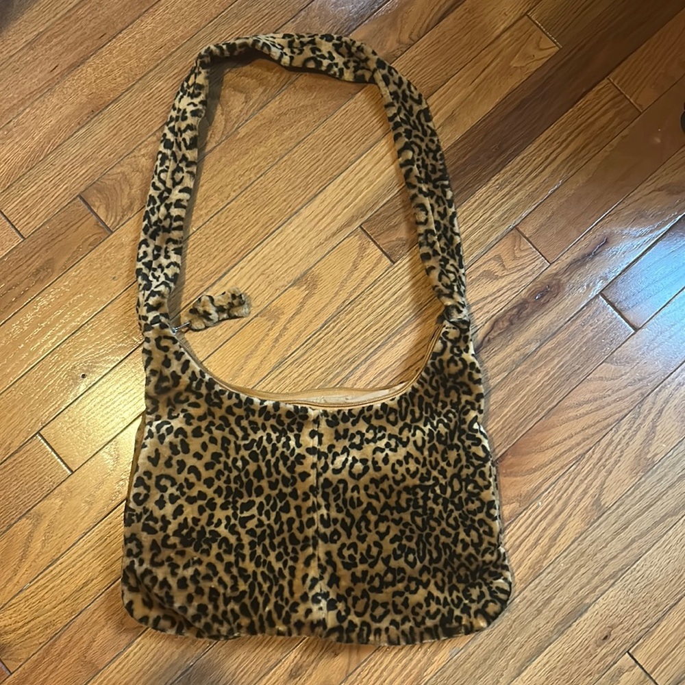 Plushy leopard print shoulder bag with hand pockets. Inside zipper as well.